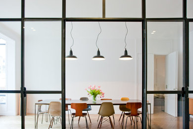 Idée de décoration pour une salle à manger ouverte sur le salon design avec un mur blanc et parquet clair.