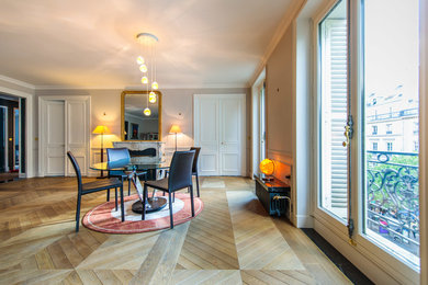 Modernes Esszimmer mit weißer Wandfarbe, hellem Holzboden und Kamin in Paris