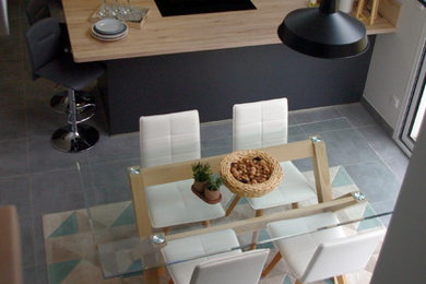 Cette image montre une salle à manger ouverte sur la cuisine minimaliste de taille moyenne avec un mur blanc, un sol en carrelage de porcelaine et un sol gris.