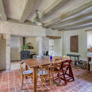Réalisation d'une salle à manger bohème avec un mur gris, un sol rouge et un plafond en poutres apparentes.