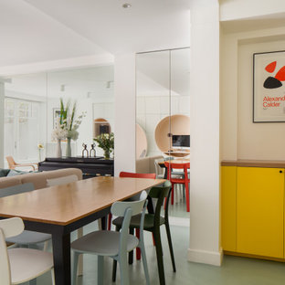 Exemple d'une salle à manger ouverte sur le salon tendance de taille moyenne avec un mur blanc et un sol vert.