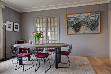 Aménagement d'une salle à manger ouverte sur le salon contemporaine de taille moyenne avec un mur gris, parquet clair et aucune cheminée.