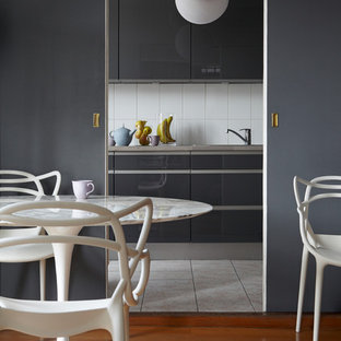 Inspiration pour une salle à manger design fermée et de taille moyenne avec un mur gris, un sol en bois brun et aucune cheminée.