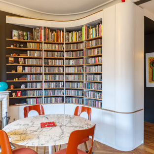 Idée de décoration pour une salle à manger bohème avec un mur noir, un sol en bois brun et un sol marron.