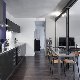 Cette image montre une grand salle à manger ouverte sur le salon design avec un mur blanc, un sol en bois foncé et aucune cheminée.