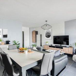 Cette photo montre une salle à manger ouverte sur le salon tendance de taille moyenne avec un mur gris, un sol en carrelage de porcelaine et un sol gris.