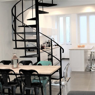 Exemple d'une salle à manger ouverte sur le salon moderne avec un mur blanc, aucune cheminée et un sol gris.