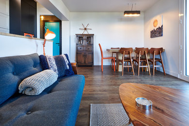 Cette image montre une salle à manger ouverte sur le salon bohème de taille moyenne avec un mur blanc, un sol en vinyl et un sol marron.