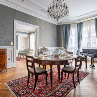 Inspiration pour une grand salle à manger victorienne fermée avec un mur bleu, un sol en bois brun, une cheminée standard, un sol marron et un plafond en poutres apparentes.