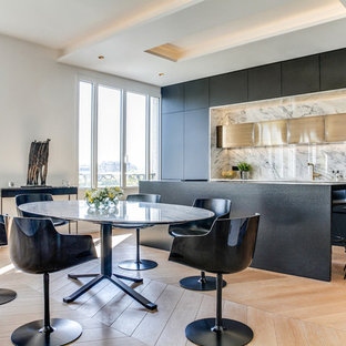 Idée de décoration pour une salle à manger ouverte sur la cuisine design avec un mur blanc, un sol en bois clair et aucune cheminée.