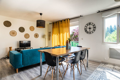 Cette image montre une salle à manger ouverte sur le salon design de taille moyenne avec un mur blanc, un sol en vinyl, aucune cheminée et un sol marron.