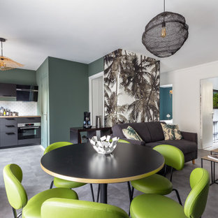 Cette image montre une salle à manger ouverte sur le salon design de taille moyenne avec un sol en vinyl, un sol gris et un mur blanc.
