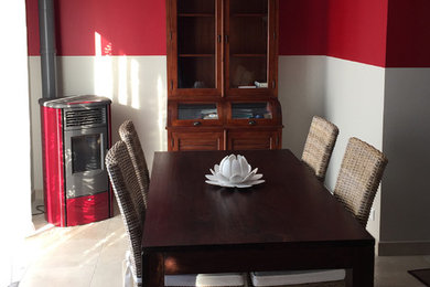 Cette photo montre une salle à manger avec un sol en carrelage de céramique, un poêle à bois et un sol gris.