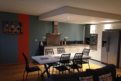 Exemple d'une salle à manger ouverte sur le salon moderne de taille moyenne avec un mur bleu, parquet clair et un sol beige.