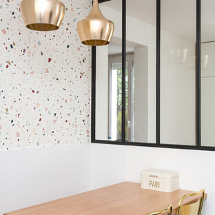 Cette photo montre une salle à manger ouverte sur la cuisine tendance avec un mur blanc.