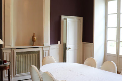 Exemple d'une salle à manger chic de taille moyenne avec un mur violet, parquet clair, un sol marron et boiseries.