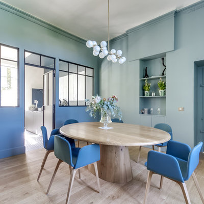 Example of a trendy light wood floor and beige floor enclosed dining room design in Bordeaux with blue walls