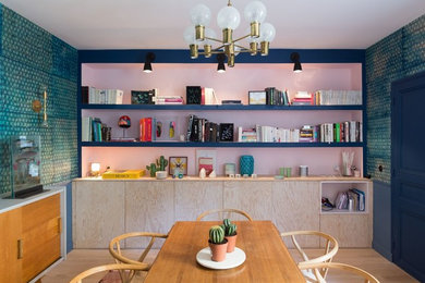 Aménagement d'une grande salle à manger contemporaine fermée avec parquet clair, un sol marron et un mur bleu.