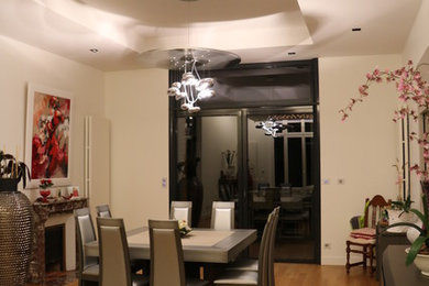 Réalisation d'une salle à manger design fermée et de taille moyenne avec un mur blanc, un sol en bois brun et une cheminée standard.