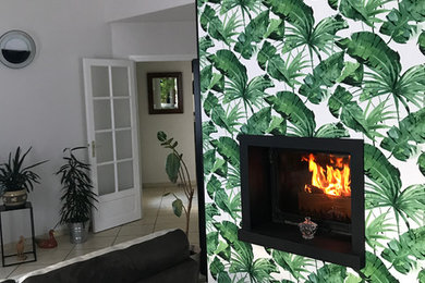 トゥールーズにあるお手頃価格の中くらいなトロピカルスタイルのおしゃれなLDK (緑の壁、セラミックタイルの床、ベージュの床、吊り下げ式暖炉) の写真