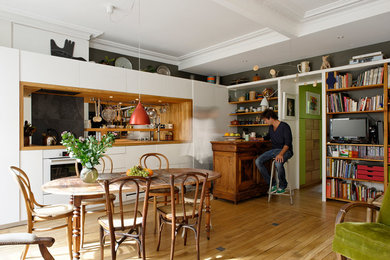Ejemplo de comedor ecléctico de tamaño medio abierto con suelo de madera en tonos medios, paredes blancas y suelo beige
