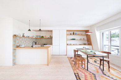 Imagen de comedor contemporáneo de tamaño medio abierto sin chimenea con paredes blancas, suelo de madera clara y suelo blanco