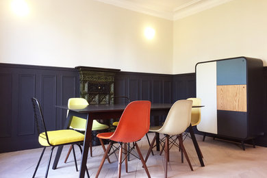 Modelo de comedor actual de tamaño medio cerrado con paredes multicolor, suelo de madera clara, estufa de leña y marco de chimenea de baldosas y/o azulejos