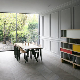 Exemple d'une grand salle à manger tendance avec un mur gris, un sol en bois clair et aucune cheminée.