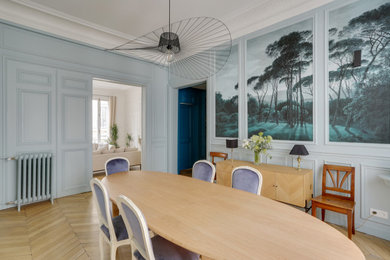 Immagine di una grande sala da pranzo chiusa con pareti verdi, parquet chiaro e pavimento marrone