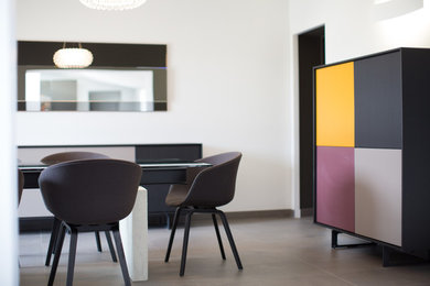 Cette image montre une salle à manger design fermée et de taille moyenne avec un mur gris, un sol en carrelage de céramique, un poêle à bois et un sol gris.