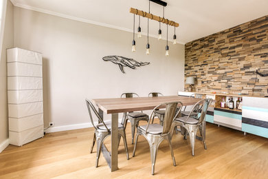 Inspiration pour une salle à manger ouverte sur le salon design avec un mur gris et parquet clair.