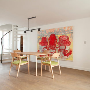 Idée de décoration pour une grand salle à manger ouverte sur le salon design avec un mur blanc et un sol en bois clair.