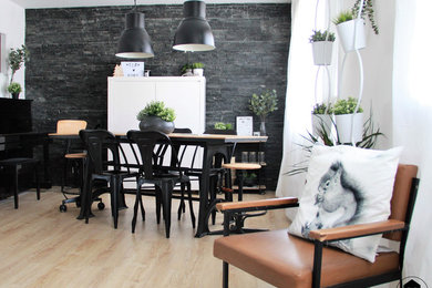 Foto de comedor urbano de tamaño medio con paredes negras, suelo de madera clara y suelo marrón