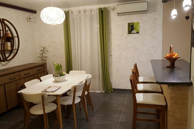 Cette photo montre une salle à manger ouverte sur le salon moderne avec un mur beige et un sol en carrelage de céramique.