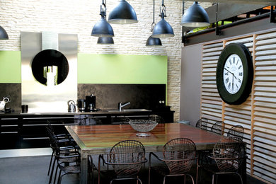Idées déco pour une salle à manger ouverte sur la cuisine industrielle de taille moyenne avec un mur multicolore.