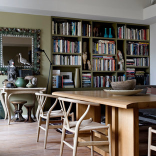 Idées déco pour une salle à manger ouverte sur le salon éclectique de taille moyenne avec un mur vert, un sol en bois clair et aucune cheminée.