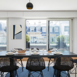 Inspiration pour une salle à manger design avec un mur blanc, un sol en bois clair, aucune cheminée et un sol beige.