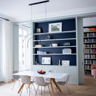Idée de décoration pour une salle à manger design avec un mur blanc, un sol en bois clair et un sol beige.