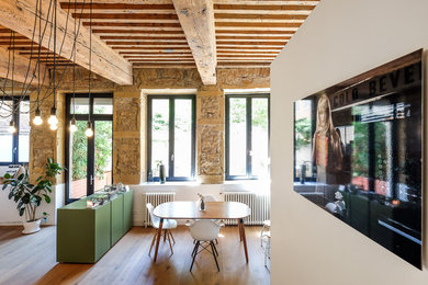 Aménagement d'une salle à manger contemporaine avec un mur blanc et un sol en bois brun.