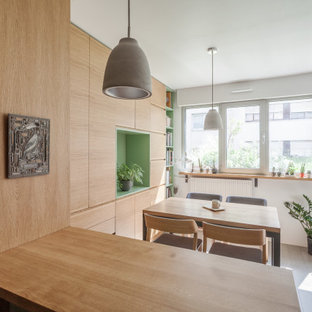 Immagine di una piccola sala da pranzo aperta verso la cucina nordica con pareti bianche, pavimento in legno verniciato, nessun camino, pavimento grigio e pareti in legno