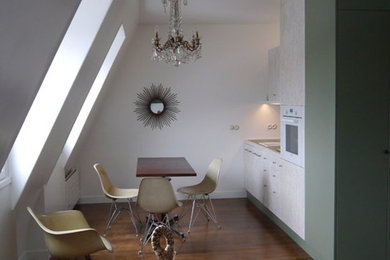 Modelo de comedor minimalista pequeño con paredes blancas y suelo de madera en tonos medios