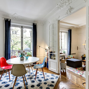 Cette image montre une grand salle à manger ouverte sur le salon traditionnelle avec un mur blanc, un sol en bois brun et aucune cheminée.