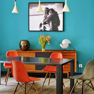 Inspiration pour une salle à manger bohème fermée et de taille moyenne avec un mur bleu, un sol en bois brun et aucune cheminée.