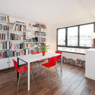 Exemple d'une salle à manger ouverte sur le salon tendance de taille moyenne avec un mur blanc, un sol en bois foncé et un sol marron.