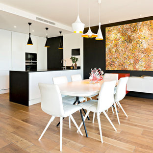 Idée de décoration pour une grand salle à manger ouverte sur la cuisine design avec un mur noir, un sol en carrelage de céramique et un sol marron.