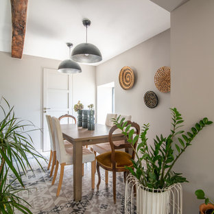 Cette photo montre une salle à manger tendance fermée avec un mur gris, un sol en carrelage de porcelaine et un sol multicolore.