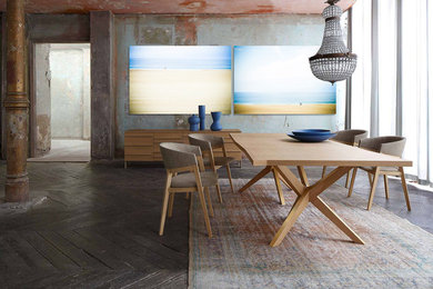 Exemple d'une grande salle à manger ouverte sur le salon tendance avec un sol en bois brun et un mur gris.