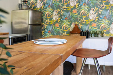 Idée de décoration pour une salle à manger ouverte sur le salon de taille moyenne avec un mur blanc, sol en stratifié et un sol beige.