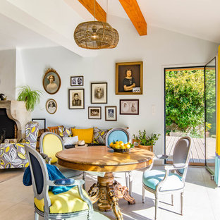 Aménagement d'une grand salle à manger ouverte sur le salon éclectique avec un mur bleu, un sol en carrelage de céramique, une cheminée standard, un manteau de cheminée en plâtre et un sol gris.