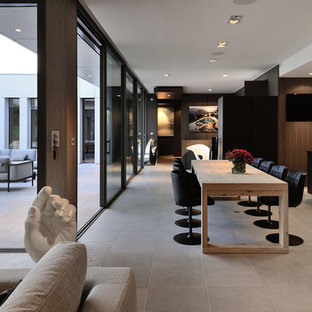 Aménagement d'une très grand salle à manger ouverte sur le salon contemporaine avec un mur marron.